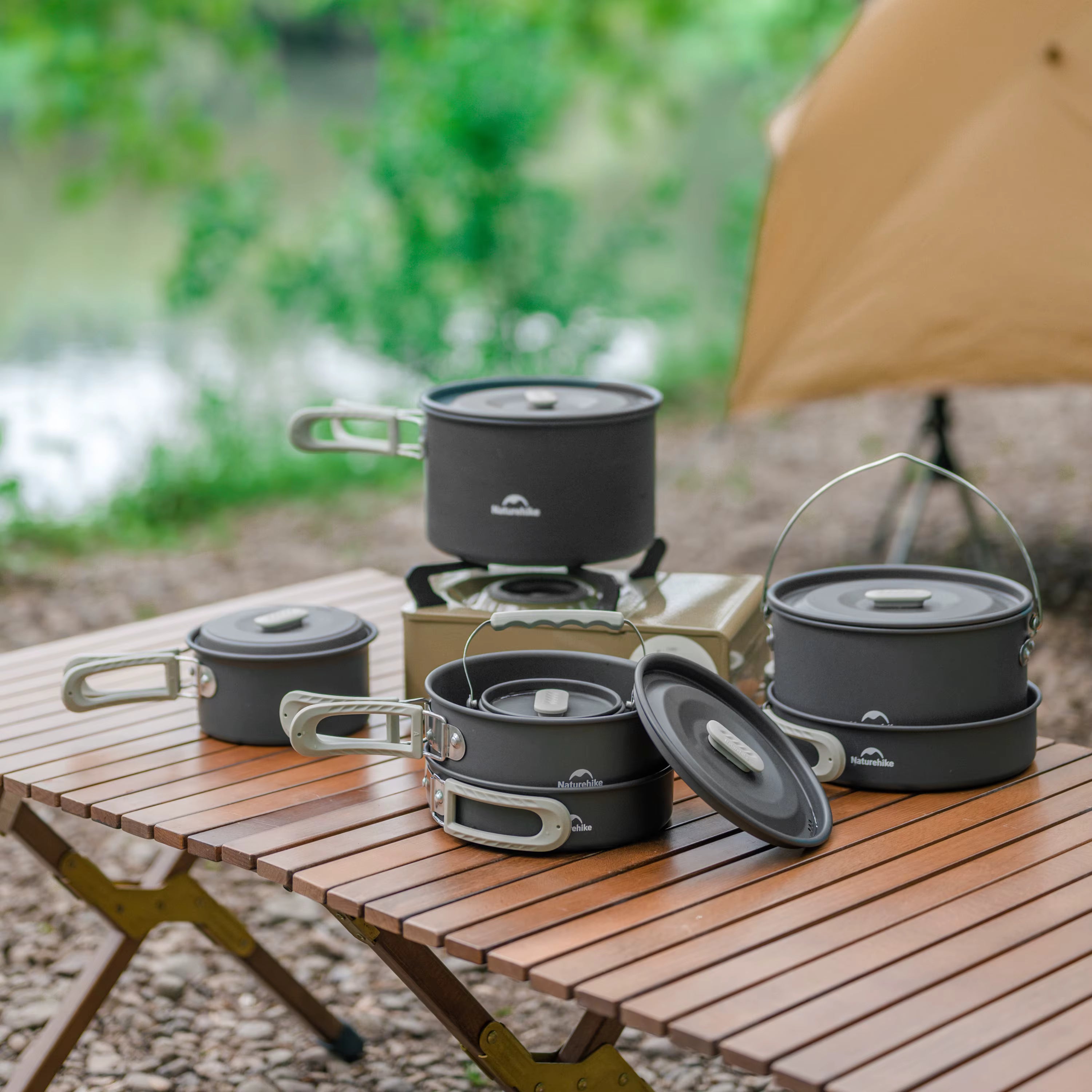 Camping cookware set on a wooden table with a natural background