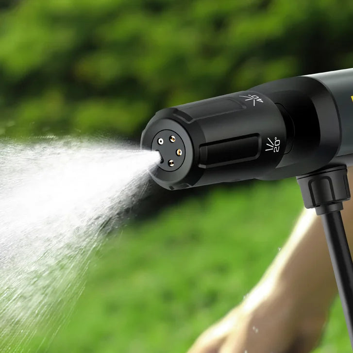 Black garden hose nozzle spraying water with a blurred green background