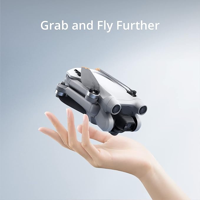 Small drone held in a hand with 'Grab and Fly Further' text on a gradient background