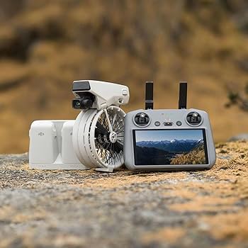 Drone and remote control with screen displaying a mountain landscape on a textured surface.