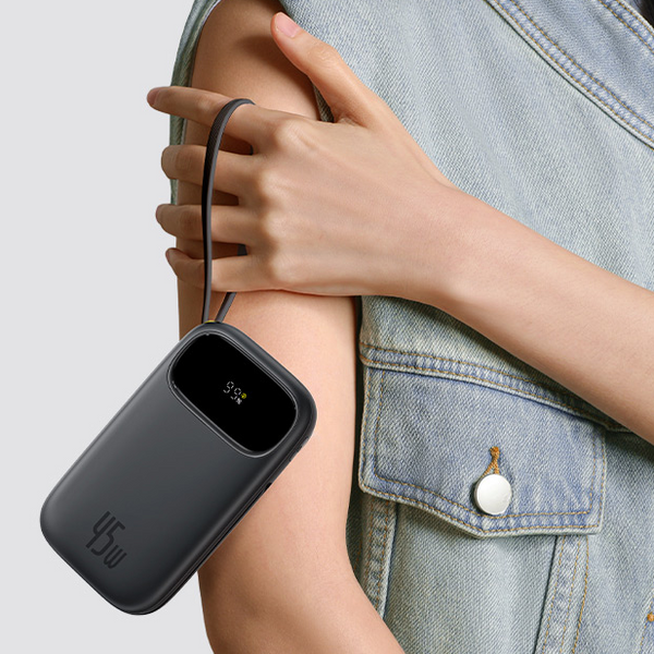Person holding a black power bank against a light gray background