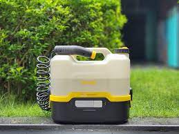 White and yellow pressure washer on a grassy area