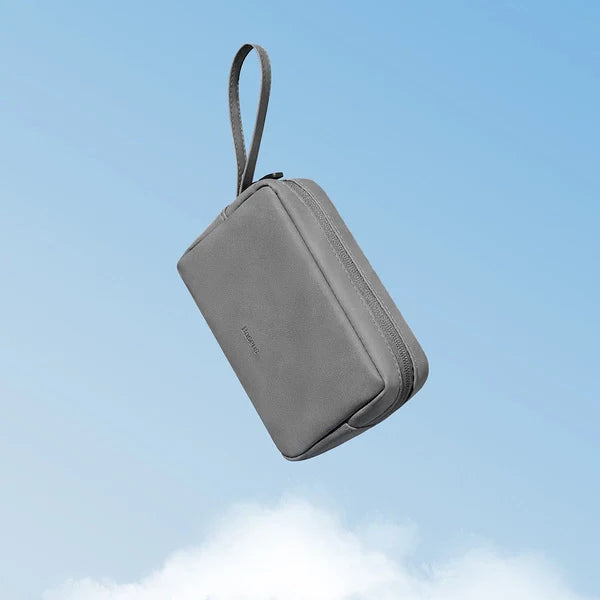 Gray travel organizer with a handle against a blue sky background