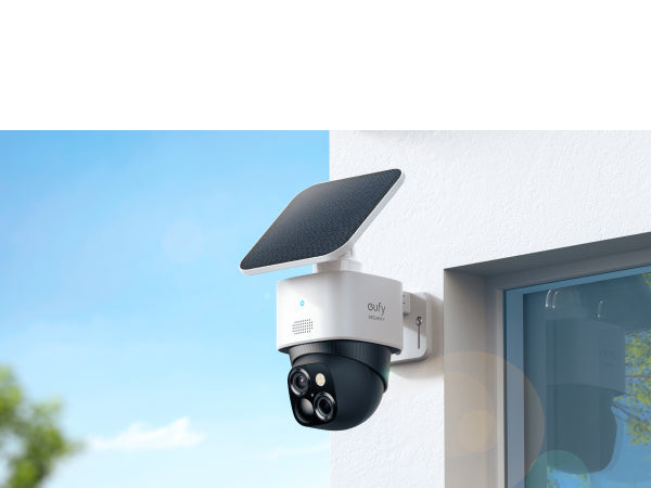 Solar-powered security camera attached to a wall with a clear sky background