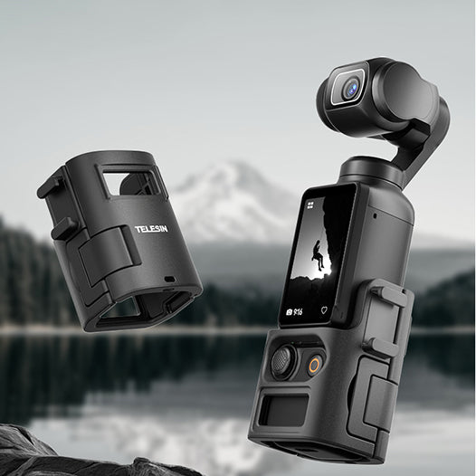 Black camera with screen and lens cover against a blurred natural background
