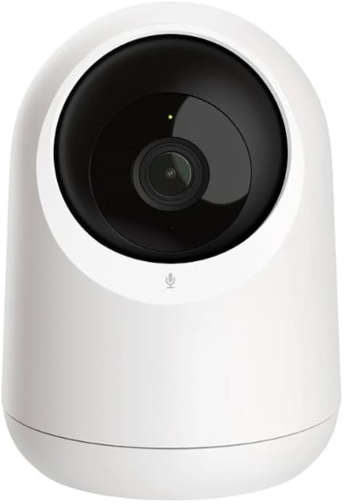 White security camera with black lens on a white background